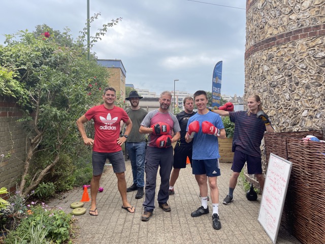 a group of people with boxing gloves smile at the camera