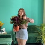 Volunteer grace smiling with a plant