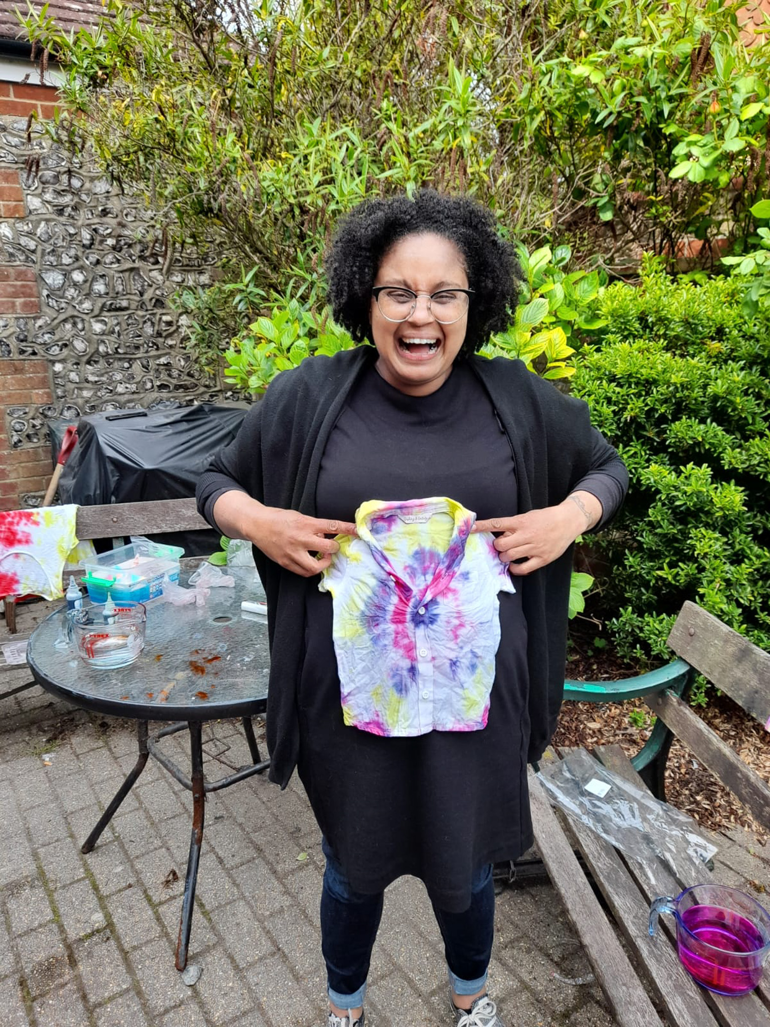 Sasha simles holding up a tie-dyed T-Shirt